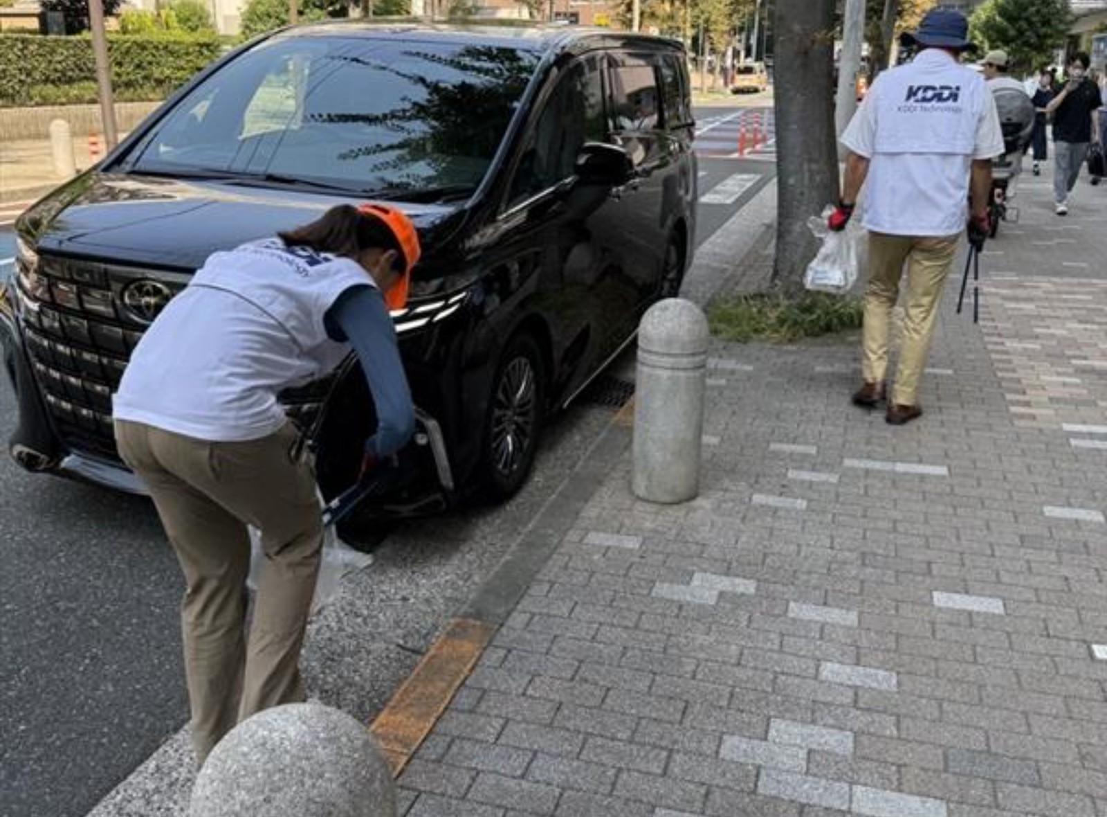 駐輪場周辺の植え込みからゴミを拾う様子の写真